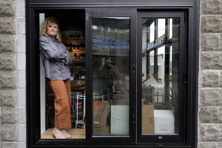 Lauren Friel, owner of Rebel Rebel Wine Bar, in Somerville, Mass., stands for a portrait at the wine bar Thursday. An Associated Press review of the small business aid passed by Congress as part of its coronavirus stimulus package shows that larger companies could quickly claim a disproportionate share of the money, squeezing out many small, locally-based businesses.