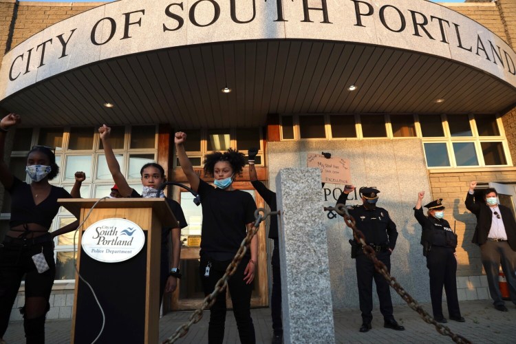 Student protesters are joined by police Thursday at the South Portland police station in a demonstration against institutional racism.