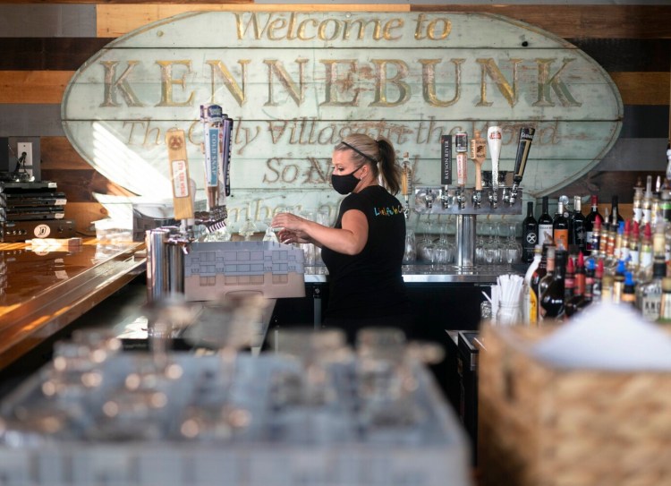 Preparing for the start of indoor dining this week, Sarah Chadbourne gets the bar area ready at Duffy's Tavern and Grill in Kennebunk on Monday.