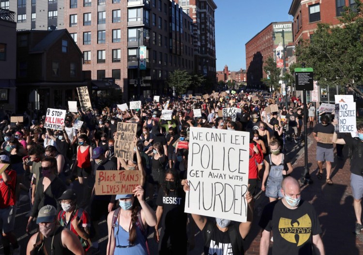 Demonstrators march on Congress Street during a Juneteenth Black Lives Matter rally in Portland on June 19. Another protest planned for Saturday has been postponed by BLM organizers, but they acknowledge people may show up anyway.