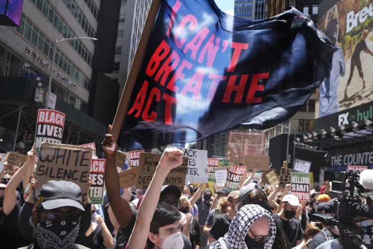 Protesters rally near the edge of Times Square in New York City on Sunday. The city is opening 15 coronavirus testing sites, urging protesters to go. 