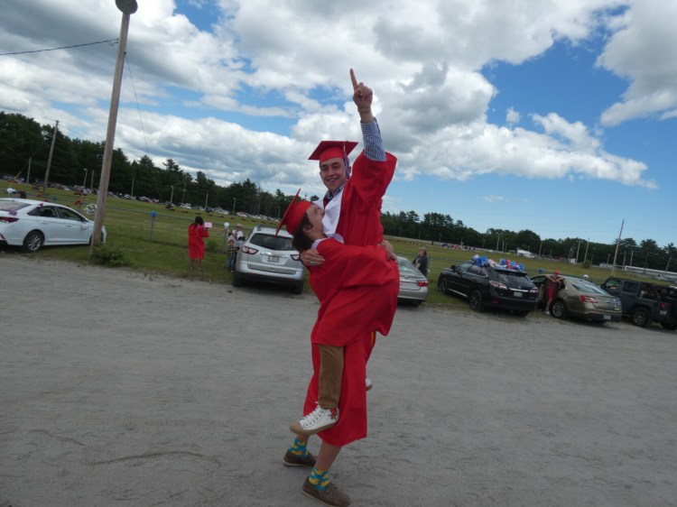 Cody Holman hoists classmate Cam Wallace into the air after the two graduated from Mt. Ararat High School Sunday. 