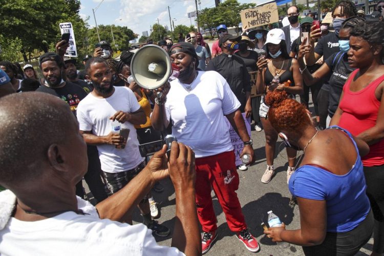 Ashley Brooks speaks as protestors gather on University Avenue near a Wendy's restaurant Saturday in Atlanta. Georgia authorities said Saturday a man was shot and killed in a late night struggle with Atlanta police outside a fast food restaurant after he failed a field sobriety test and resisted arrest.