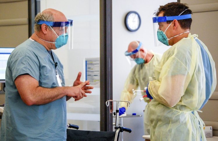 Dr. Michael Saag, left, speaks with an unidentified co-worker in Birmingham, Ala., on Friday.