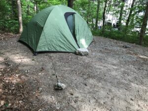 Tents today are quick to set up. And ideally should have a tarp underneath to help keep them dry and stakes to secure the fly (top cover). But if you forget your stakes, you can use large rocks to hold down the tent lines.