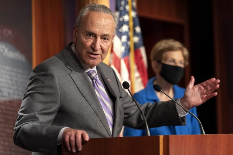 Senate Minority Leader Sen. Chuck Schumer of N.Y., left, with Sen. Elizabeth Warren, D-Mass., speaks during a news conference Wednesday on Capitol Hill in Washington.