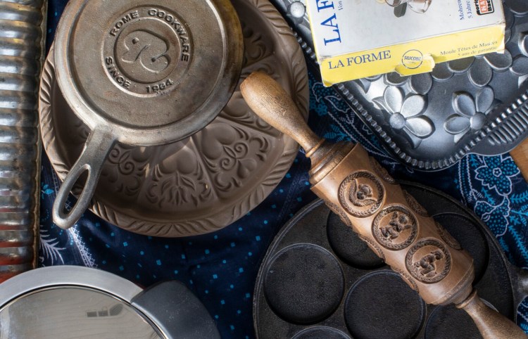 Portland Press Herald Food Editor Peggy Grodinsky unearthed a lot of specialty pans while home during the pandemic. Pictured here: a springerle rolling pin, a Nordicware Daisy Cake  pan, a Mohrenkopfform in its original box, a , decorative shortbread pan, a stovetop waffle iron, a plett pan for Swedish pancakes, a Hotpan, and a ridged Rehrucken cake pan.