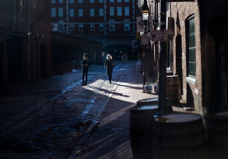 People walk on Wharf Street in Portland on  Dec. 7.