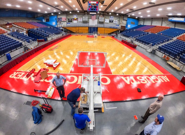 Dan Shaw, of Mountain State School Equipment, and Augusta Civic Center staffers work on the installation of the new basketball hoops on Feb. 12, 2019.