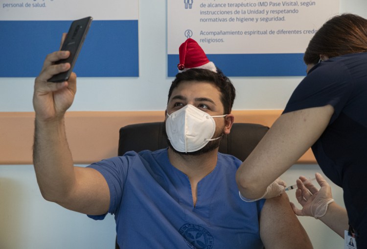 ICU Dr. German Osorio takes a selfie as he gets his COVID-19 vaccine shot at the Posta Central Hospital in Santiago, Chile, on Thursday, on the same day the first shipment of vaccines arrived from Pfizer and its German partner, BioNTech. The vaccine is believed to be effective against a new variant of the virus detected in the United Kingdom and South Africa.  