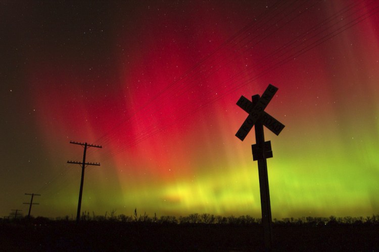 The aurora borealis lights up the sky northwest of Lawrence, Kan., in 2004. The phenomenon, also called northern lights, occurs when electrically charged particles from the sun enter the earth's atmosphere.