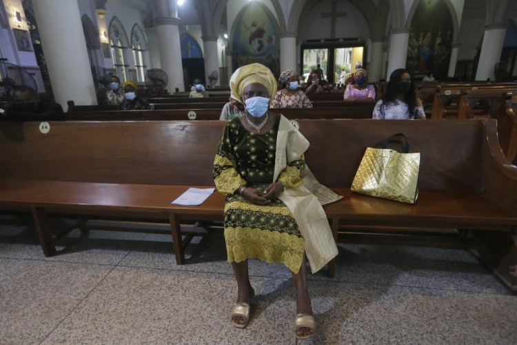 Parishioners, wearing face masks to protect against coronavirus, attend a morning Christmas Mass at Holy Cross Cathedral in Lagos, Nigeria. Africa's top public health official says another new variant of the coronavirus appears to have emerged in Nigeria, but further investigation is needed. The discovery could add to new alarm in the pandemic after similar variants were announced in recent days in Britain and South Africa and sparked the swift return of travel restrictions.
