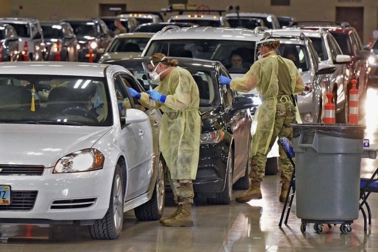 North Dakota National Guard soldiers Spc. Samantha Crabbe, left, and Master Sgt. Melanie Vincent administer COVID-19 tests inside the Bismarck Events Center in Bismarck, N.D., last month. 

