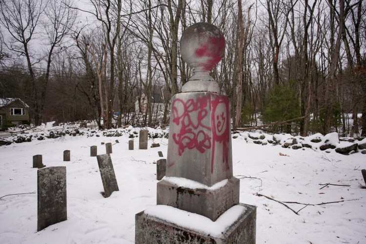 WATERBORO, ME - JANUARY 11: Spray painted words and a picture mar a gravestone at the Roberts-Wakefield Cemetery in Waterboro, photographed on Monday, January 11, 2021. The York County Sheriff's Office is investigating the vandalism that defaced nearly a dozen grave markers in the historic cemetery. (Staff photo by Gregory Rec/Staff Photographer)