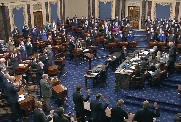 Sen. Patrick Leahy, D-Vt., the president pro tempore of the Senate, who is presiding over the impeachment trial of former President  Trump, swears in members of the Senate for the impeachment trial at the U.S. Capitol in Washington on Tuesday.