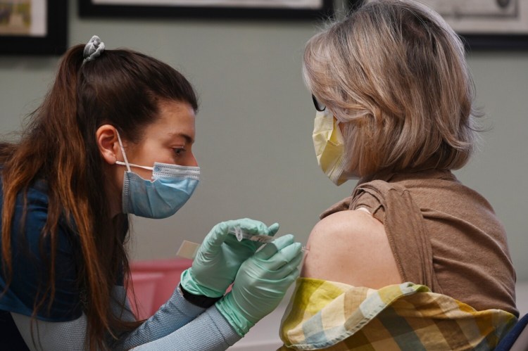 Sandy Mait, an AEMT, gives a vaccine to Mineta Scott of Eliot during the vaccination clinic at St Christopher's Church in York on Wednesday. 