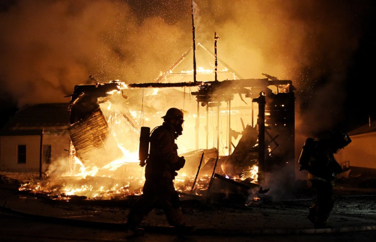 Firefighters work the scene of a fire at the Town Hall building in Jefferson, N.H. on Monday night. (Paul Hayes/Caledonian-Record via AP)