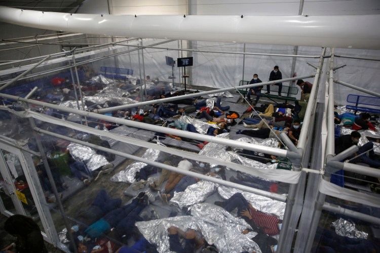 Minor children rest inside a pod at the Donna Department of Homeland Security holding facility, the main detention center for unaccompanied children in the Rio Grande Valley run by U.S. Customs and Border Protection (CBP), in Donna, Texas, Tuesday, March 30, 2021. The minors are housed by the hundreds in eight pods that are about 3,200 square feet in size. Many of the pods had more than 500 children in them. The Biden administration on Tuesday for the first time allowed journalists inside its main detention facility at the border for migrant children, revealing a severely overcrowded tent structure where more than 4,000 kids and families were crammed into pods and the youngest kept in a large play pen with mats on the floor for sleeping.(AP Photo/Dario Lopez-Mills, Pool)