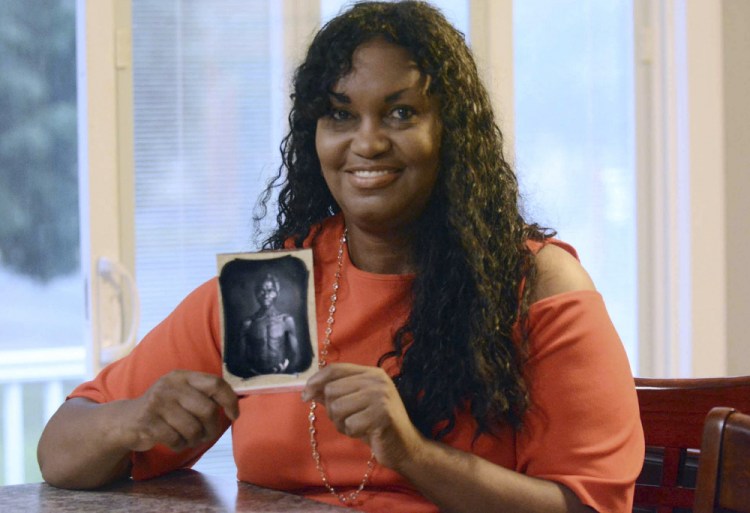 Tamara Lanier holds an 1850 photograph July 17, 2018, at her home in Norwich, Conn., of a South Carolina slave named Renty, who Lanier said is her family's patriarch. The portrait was commissioned by Harvard biologist Louis Agassiz, whose ideas were used to support the enslavement of Africans in the United States.
