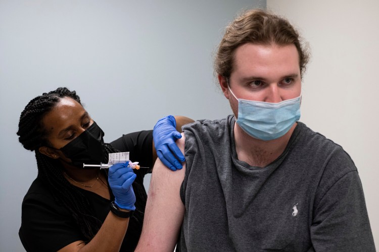 Cole Smith receives a Moderna variant vaccine shot from clinical research nurse Tigisty Girmay at Emory University's Hope Clinic on March 31 in Decatur, Ga. Smith, who received Moderna's original vaccine a year ago in a first-stage study, said returning wasn’t a tough decision. “The earlier one, it was a great success and, you know, millions of people are getting vaccinated now. ... If we’re helping people with the old one, why not volunteer and help people with the new one?” 