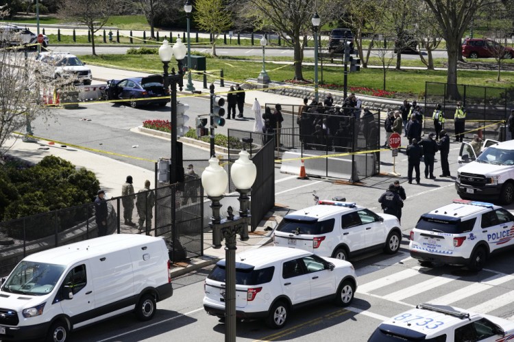 Police officers gather near a car that crashed into a barrier on Capitol Hill in Washington, Friday, April 2. 