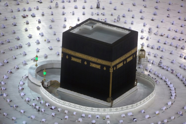 Muslims pray during the first dawn prayers of the Islamic holy month of Ramadan, around the Kaaba, the cubic building at the Grand Mosque, as they keep distanced to help curb the spread of the coronavirus on Tuesday in Mecca, Saudi Arabia. 