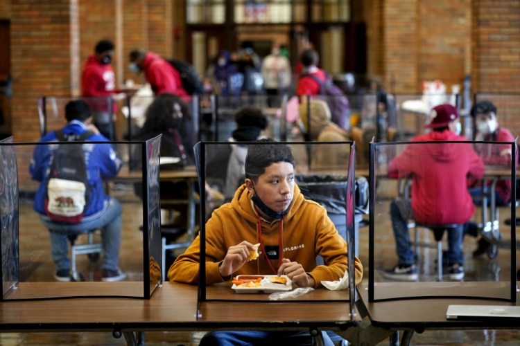 Freshman Hugo Bautista eats lunch at Wyandotte County High School on Wednesday in Kansas City, Kan., on the first day of in-person learning. 