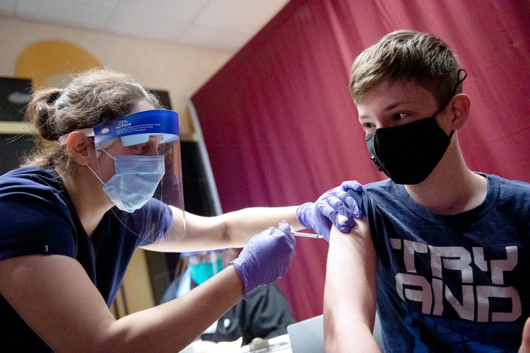 Emery Ouellette, 13, of New Gloucester is given his COVID-19 vaccine by Dr. Lauren Nadkarni at the Auburn Mall vaccination clinic. Wednesday was the first day that children between the ages of 12 and 15 were eligible for the vaccine. Ouellette is a student at Gray-New Gloucester Middle School.