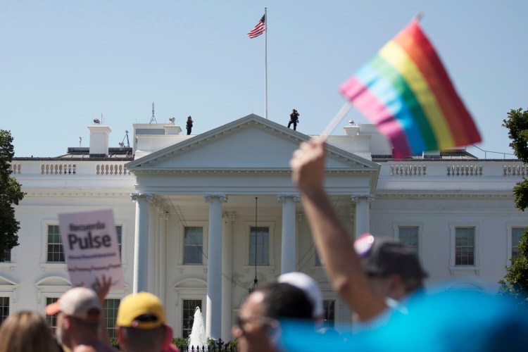 FILE - In this Sunday, June 11, 2017 file photo, Equality March for Unity and Pride participants march past the White House in Washington. The Biden administration says the government will protect gay and transgender people against sex discrimination in health care. That reverses a Trump-era policy that sought to narrow the scope of legal rights in sensitive situations involving medical care. Health and Human Services Secretary Xavier Becerra said Monday that LGBTQ people should have the same access to health care as everyone else. T(AP Photo/Carolyn Kaster)