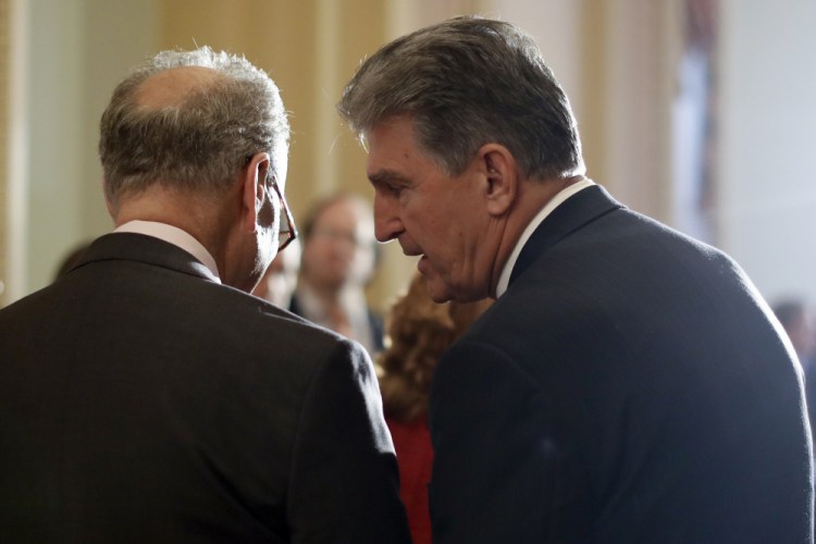 Sen. Joe Manchin, D-W.Va., right, speaks to Sen. Chuck Schumer, D-N.Y., in 2017. 