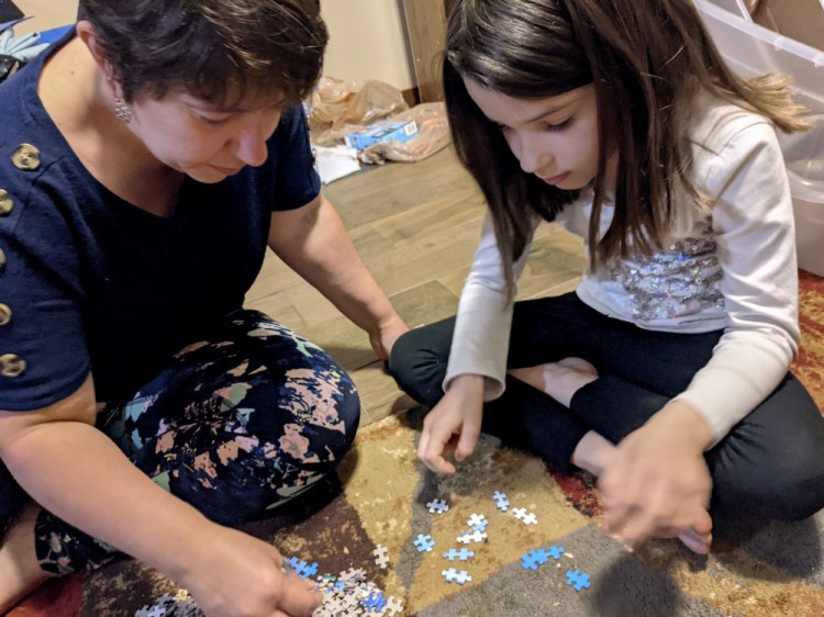 Christina Neu works on a puzzle with her 6-year-old daughter Charissa Wednesday in Wichita, Kan. Neu didn't enroll Charissa in kindergarten last fall even though she would have been one of the older kids in her class because of concerns about the pandemic.