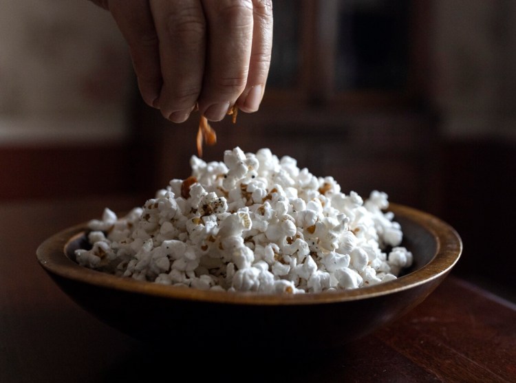 BRUNSWICK, ME - JULY 8: Christine Burns Rudalevige tops her popcorn with on Thursday July 8, 2021. (Staff photo by Brianna Soukup/Staff Photographer)