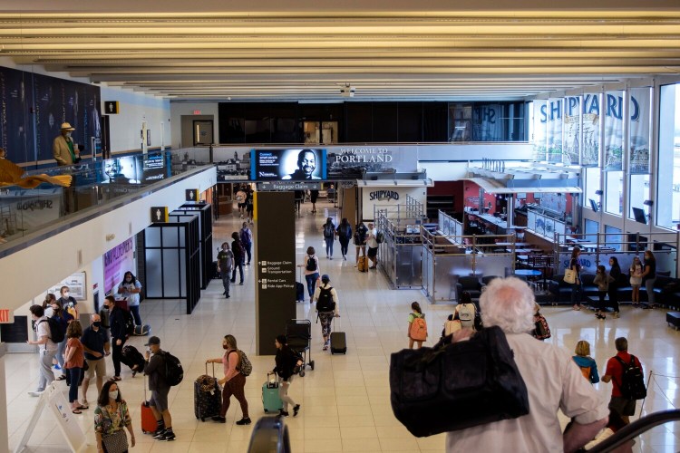 PORTLAND, ME - JULY 20: Travelers move through Portland International Jetport on Wednesday after arriving in Maine. (Staff photo by Derek Davis/Staff Photographer)