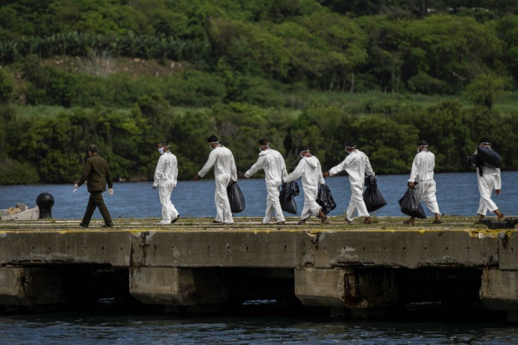 Cuban deportees walk to a COVID-19 control center where they will be quarantined after being handed over to the Cuban authorities June 29 at Orozco Bay in Artemisa, Cuba. The U.S. Coast Guard repatriated 18 Cuban nationals that were found at sea attempting to migrate illegally into the United States.