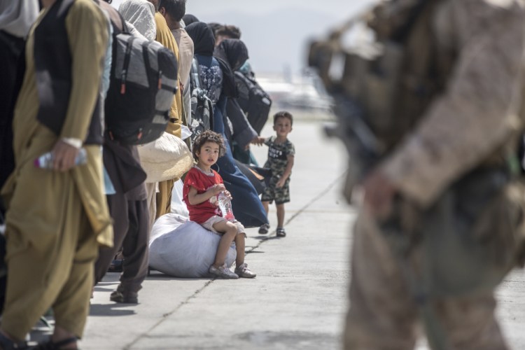 A child waits with her family to board a U.S. Air Force Boeing C-17 Globemaster III during an evacuation at Hamid Karzai International Airport in Kabul, Afghanistan, on Sunday. 