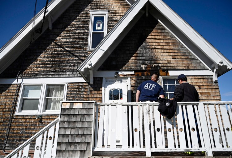 Investigators look over the damage done by suspected arson at Portland New Church Monday, September 27, 2021. 