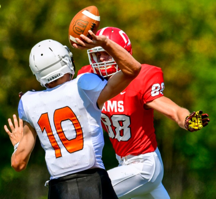 Skowhegan quarterback Adam Savage gets the pass off under pressure from Cony defensive end Casey Mills during a football game last season at Messalonskee High School in Oakland. Savage's pass was intercepted and returned for a touchdown by Cony safety Sam Flannery.