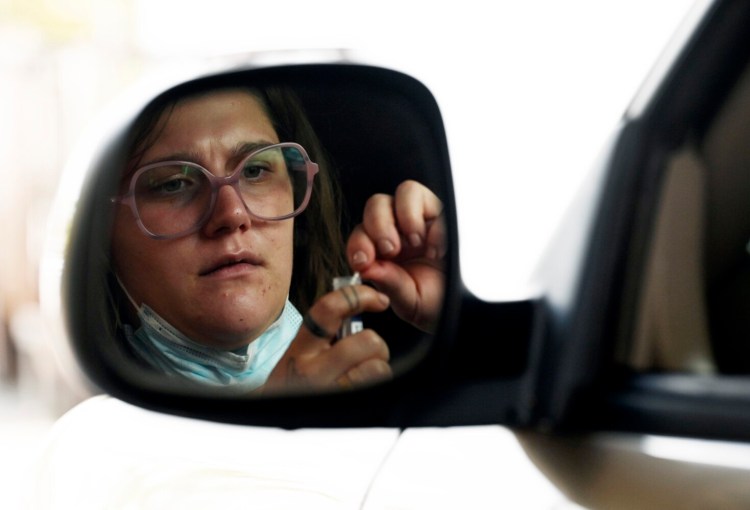 PORTLAND, ME - SEPTEMBER 10: Matanah Betko of Portland uses a specimen collection kit at the COVID-19 drive up testing clinic at Northern Light Mercy Hospital's Fore River Parkway campus Friday, September 10, 2021.  Northern Light Mercy Hospital reopened its COVID-19 drive up testing clinic at its Fore River Parkway campus on Friday. (Staff Photo by Shawn Patrick Ouellette/Staff Photographer)