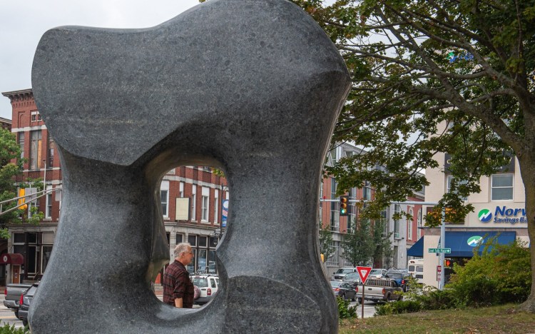 A man walks past a new art installation by Maine Artist Hugh Lassen dubbed "Bud Form" on the Auburn side of the James B. Longley Memorial Bridge Wednesday afternoon.