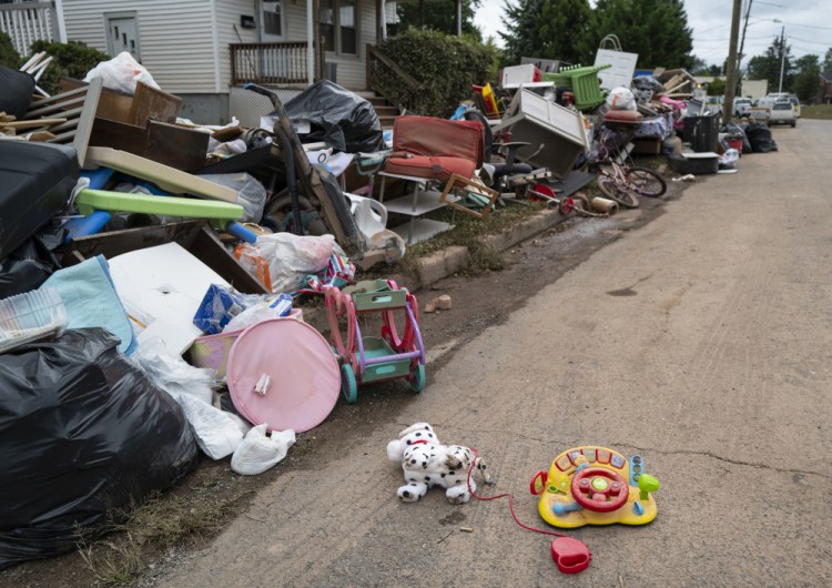 Debris from flood damage caused by the remnants of Hurricane Ida lies on the side of a street in Manville, N.J., on Sunday. Flood-stricken families and business owners across the Northeast are hauling waterlogged belongings to the curb and scraping away noxious mud as cleanup from Ida moves into high gear. 