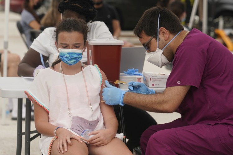 Francesca Anacleto, 12, receives her first Pfizer COVID-19 vaccine shot from nurse Jorge Tase in August in Miami Beach, Fla. In most states, minors need the consent of their parents in order to be vaccinated against COVID-19. Navigating family politics in cases of differing views has been a challenge for students and organizers of outreach campaigns, who have faced blowback for directly targeting young people.