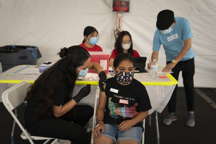 Mayra Navarrete, 13, receives the Pfizer COVID-19 vaccine from registered nurse Noleen Nobleza at a clinic set up in the parking lot of CalOptima Aug. 28 in Orange, Calif. 