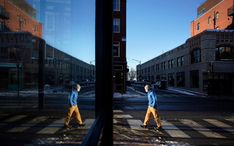 PORTLAND, ME Ð DECEMBER 20: A man wearing a mask walks along Congress Street in Portland on Monday, December 20, 2021.  (Staff photo by Gregory Rec/Staff Photographer)