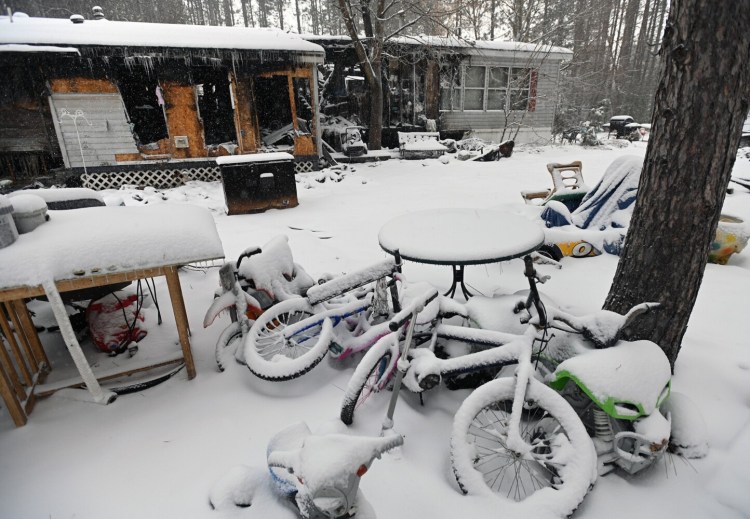 3353# 01fire SKOWHEGAN, MAINE  Bicycles are shown amidst a burned home at 15 Cedar Ridge Dr. in Skowhegan, Maine Monday January 17, 2022. (Rich Abrahamson/Morning Sentinel)