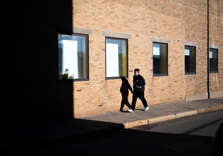 Kristopher Christiansen of South Portland walks on Oak Street in Portland after receiving a booster shot Tuesday at MaineHealth’s COVID-19 community vaccination clinic. 