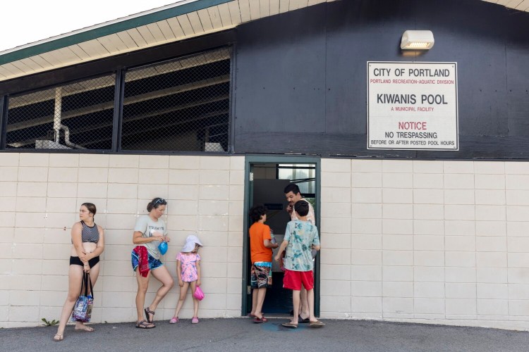 PORTLAND, ME - JULY 24: Michael Koharian waits with his two kids Malcolm, 12, and Leland, 10 to get into Kiwanis Community Pool on Sunday, July 24, 2022. The heatwave in the Northeast continued on Sunday, with temperatures nearing 90 degrees in Portland. (Staff photo by Brianna Soukup/Staff Photographer)